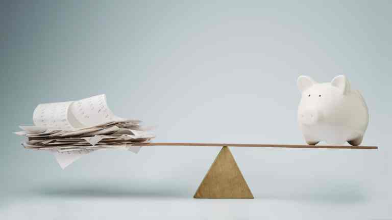 Receipts and a piggy bank balancing on a seesaw representing investment or expense